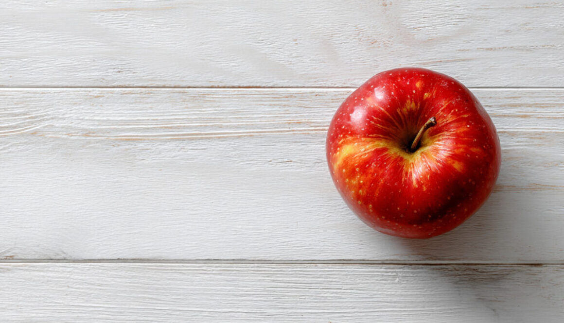 Top view of red apple on clean white wooden background – free stock phot