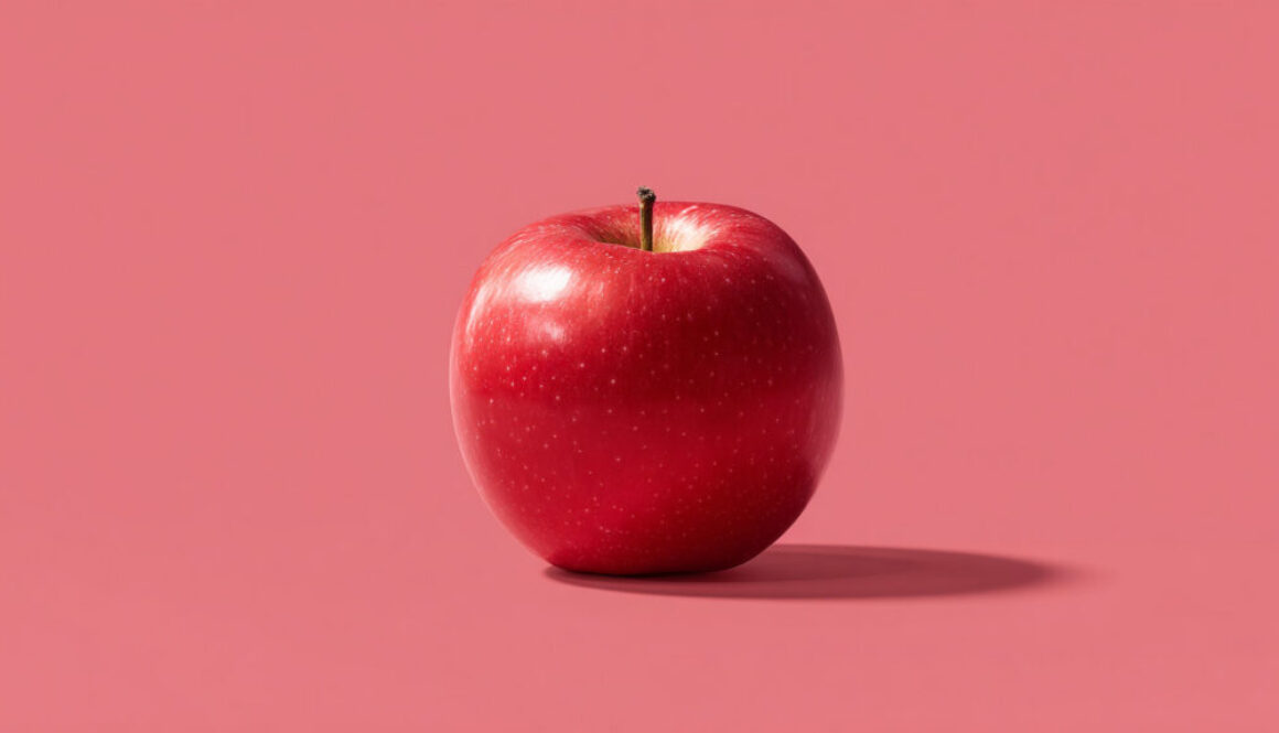 Red apple centered on a soft pink background in 16:9 format – free commercial use fruit stock image