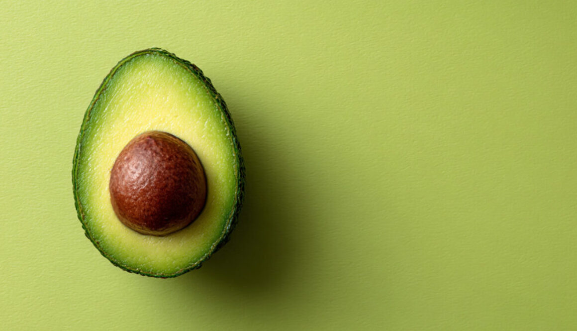Top view of ripe avocado half on kiwi green background in 16:9 format