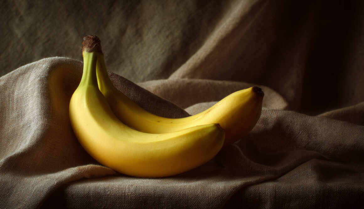 Still life of two bananas on beige fabric background in 16:9 format