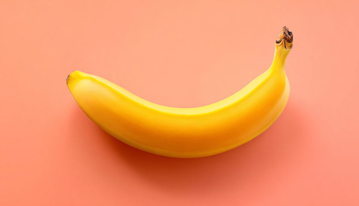 Centered ripe banana on peach background in 16:9 format