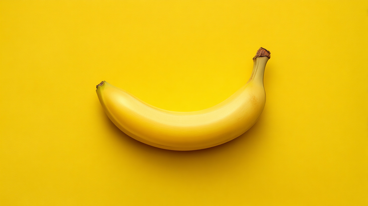 Centered ripe banana on vibrant yellow background in 16:9 format