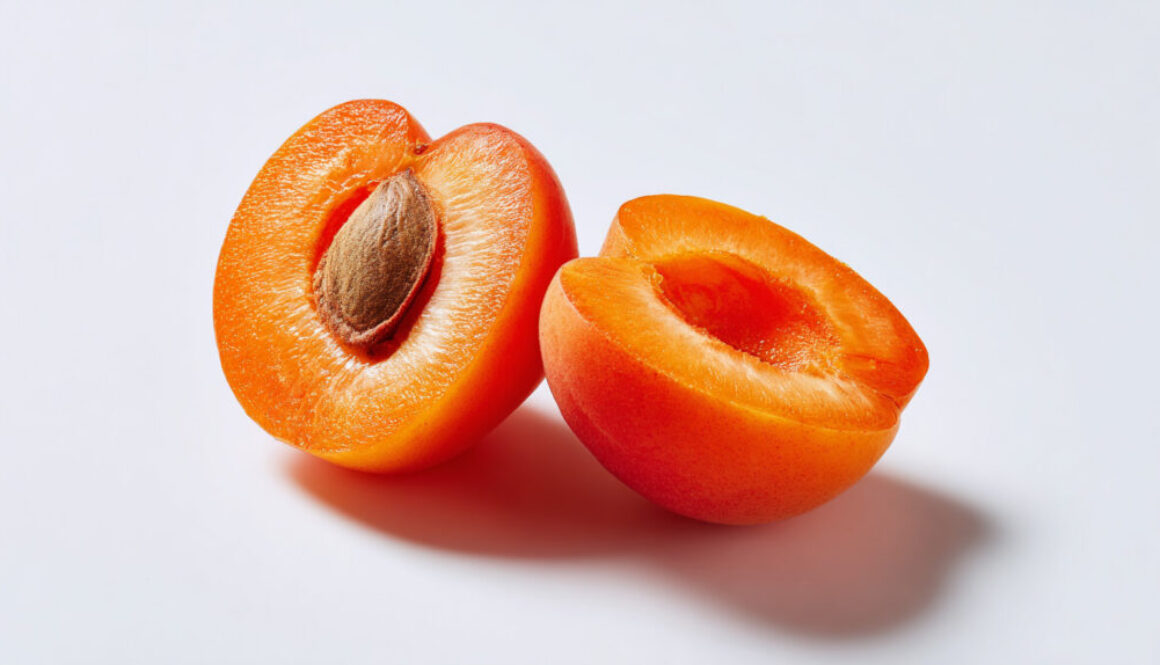 Sliced apricot with pit on white background – free stock photo