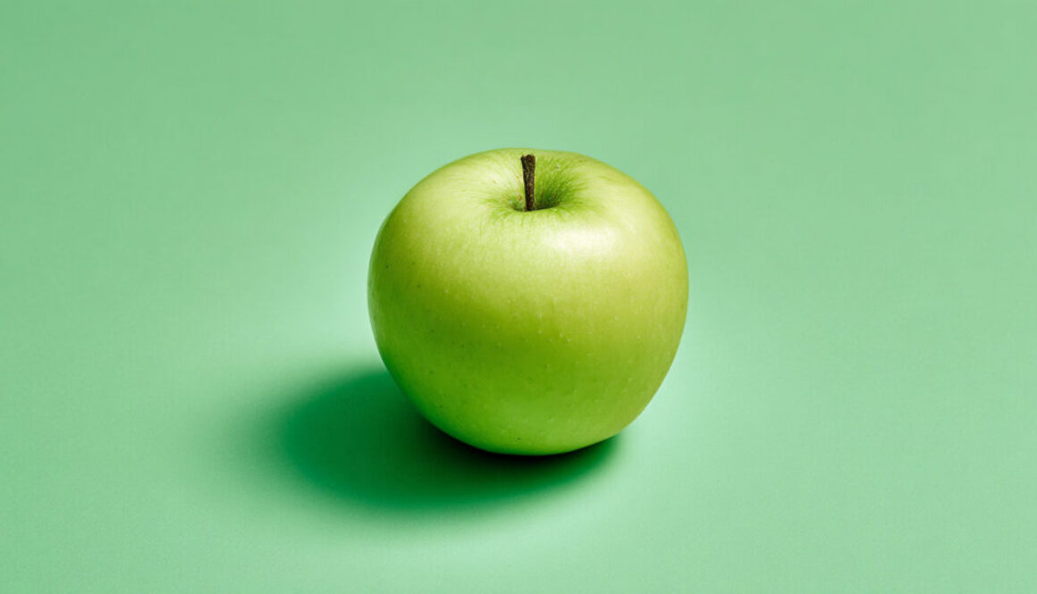 Whole green apple centered on a mint green pastel background, free 16:9 stock photo