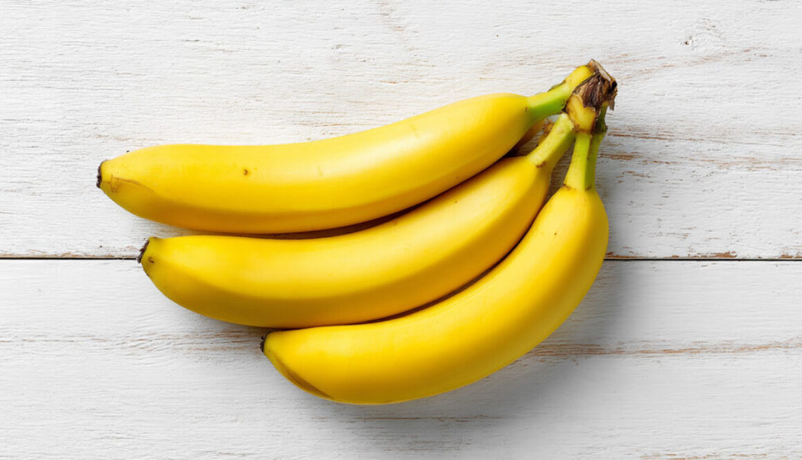 Top view of fresh banana bunch on white wooden background in 16:9 format
