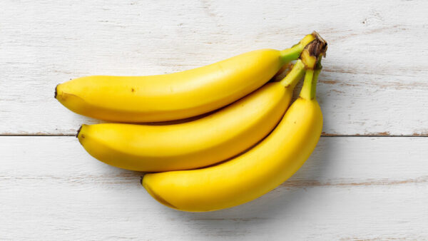 Top view of fresh banana bunch on white wooden background in 16:9 format