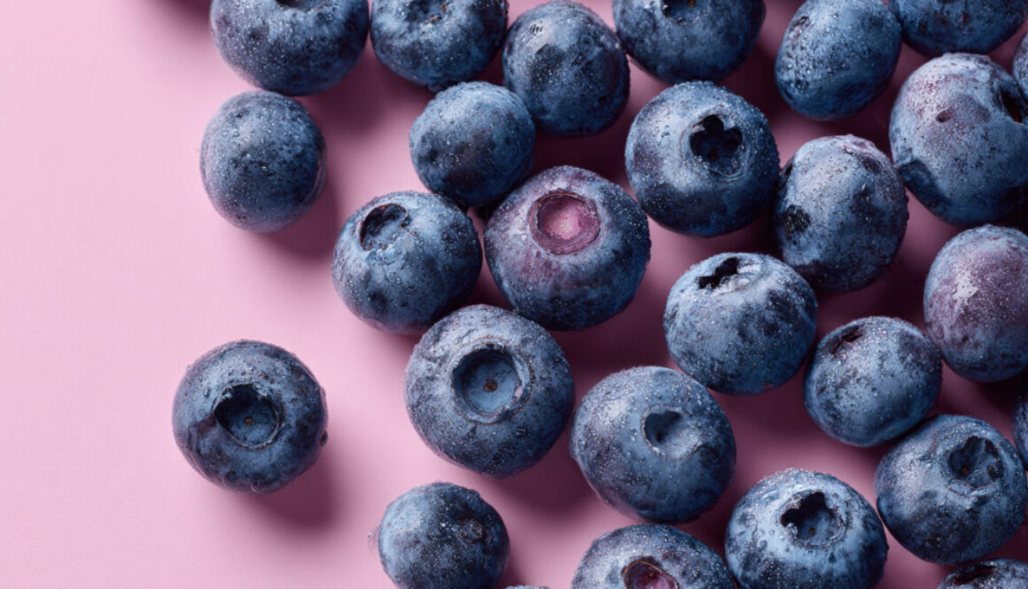 Top view of fresh blueberries on pink pastel background in 16:9 format