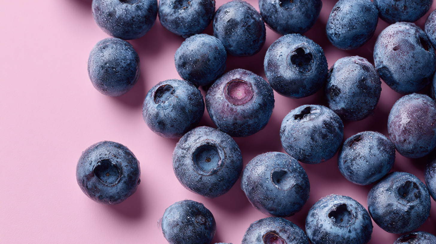 Top view of fresh blueberries on pink pastel background in 16:9 format