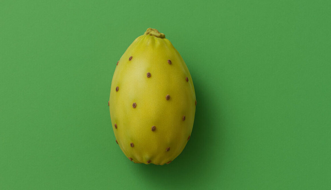 Yellow cactus fruit centered on vibrant green background in 16:9 format