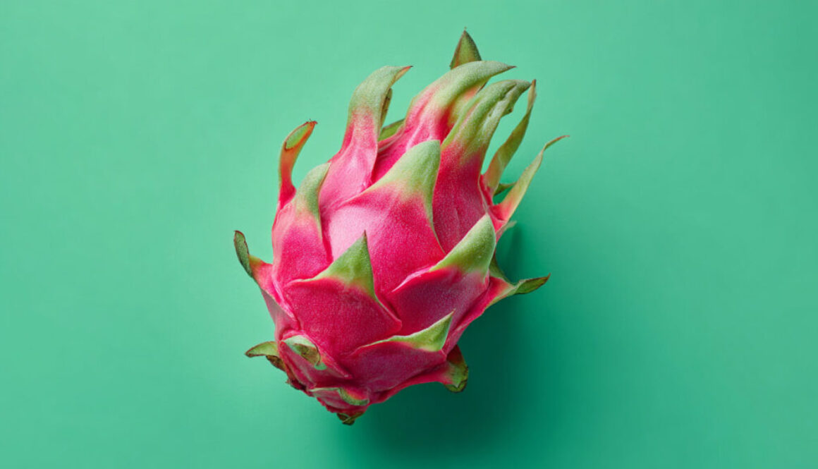 Top view of fresh dragon fruit centered on green background in 16:9 format