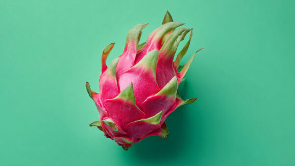 Top view of fresh dragon fruit centered on green background in 16:9 format