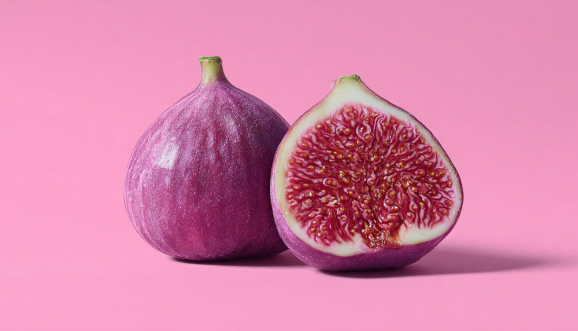 Whole and sliced ripe fig on solid pink background in high-resolution format