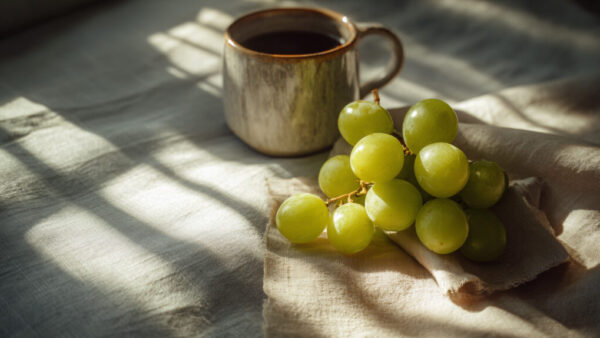 Free grapes image with coffee mug on fabric – cozy morning still life. Download 1K free on Fruttee or get the 8K premium on Gumroad.