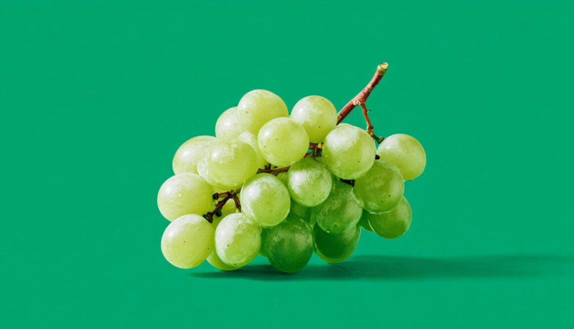 Fresh green grape cluster centered on solid green background in 16:9 format