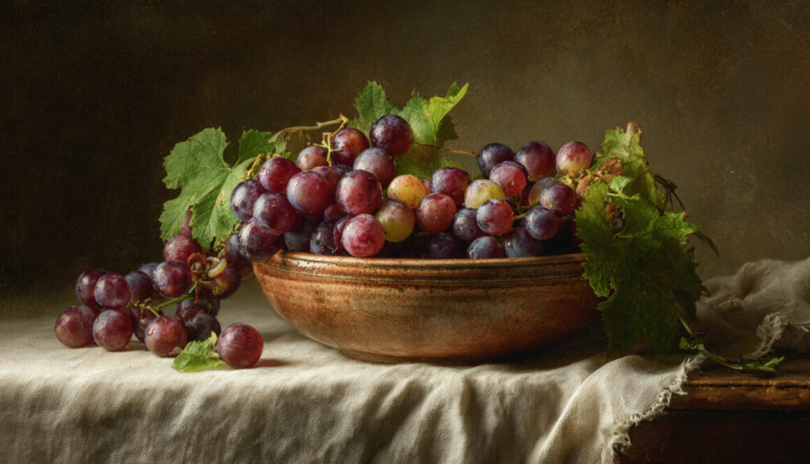Rustic still life of fresh grapes in a ceramic bowl on dark background with fabric