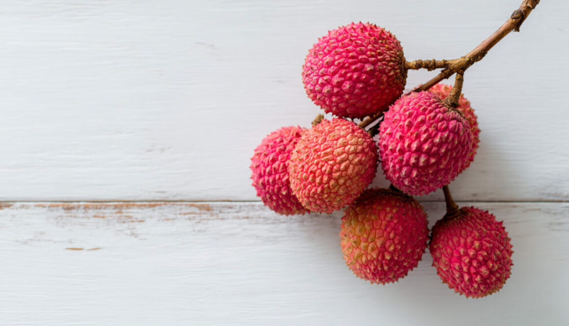 Top view of lychee branch cluster on white wooden background in 16:9 format